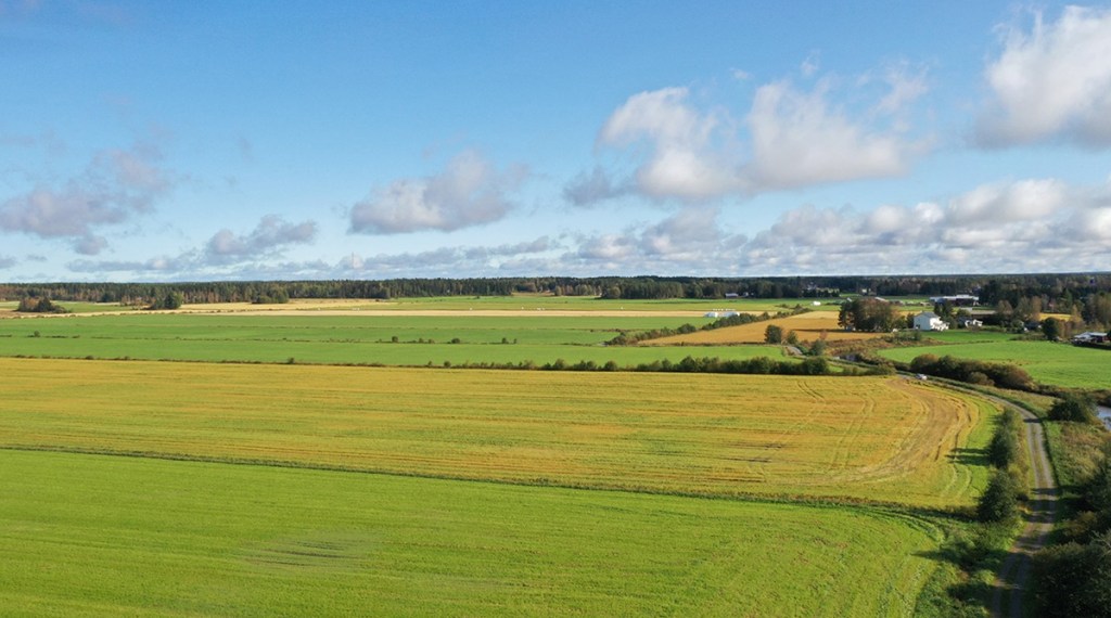 Ilmakuvassa maaseutumaisemaa ja peltoja.