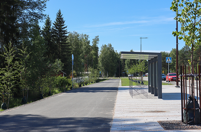 Kevyen liikenteen väylä ja pyöräkatos telineineen.